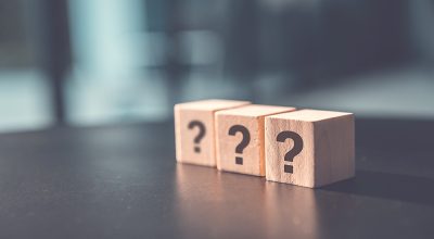 ? Questions Mark word in wooden cube block on table background.